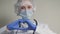 A doctor in a blue mask and gloves smiles and shows his heart, a professional cardiologist in a health clinic, an