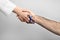 Doctor with blue ribbon on finger and patient holding hands against grey background. Symbol of medical issues