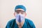 Doctor in blue suit and medical mask with fogged glasses