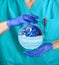 Doctor in blue uniform and gloves holding Earth globe in medical mask. Epidemic pandemic coronavirus covid-19 virus