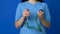 A doctor in a blue uniform holds a stethoscope in his hands close-up on a blue background