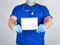doctor in blue uniform and sterile latex gloves holding open blank notebook