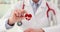 Doctor cardiologist holds in hand a red heart and icon of modern medical cardiology