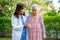 Doctor caregiver help and care Asian senior woman patient walking in park at hospital