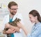 Doctor carrying while owner stroking cat at clinic