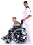 A doctor carrying a patient in a wheelchair