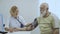 Doctor check pulse of old man with tonometer and stethoscope