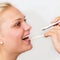 Doctor check throat of a smiling young woman