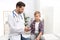 Doctor checking little boy`s pulse with medical device