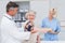 Doctor checking patients blood pressure while nurse noting it