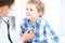 Doctor and child patient. Physician examines little boy by stethoscope. Medicine and children`s therapy concept