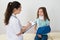 Doctor With Clipboard In Front Of Injured Patient