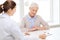 Doctor with clipboard and senior woman at hospital