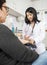 Doctor Collecting Blood From Female Patient In Clinic