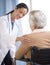 Doctor Consoling Senior Woman Sitting In Wheelchair