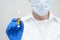 Doctor cosmetician in mask keeps in his hand in blue gloves ampoule with drug