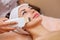 The doctor-cosmetologist makes the apparatus a procedure of ultrasound cleaning of the facial skin