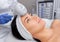 The doctor-cosmetologist makes the procedure Cryotherapy of the facial skin of a beautiful, young woman
