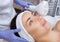 The doctor-cosmetologist makes the procedure Cryotherapy of the facial skin of a beautiful, young woman