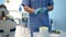 Doctor dentist in medical blue uniform makes a plaster or silicone cast of teeth using dental equipment in dentistry office