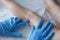 Doctor dermatologist in rubber gloves examining rash on skin of child feet closeup