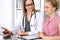 Doctor discussing confidental medical history with his patient and pointing at monitor computer