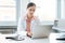 Doctor doing paperwork on computer sitting on desk