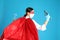 Doctor dressed as superhero posing on light blue background. Concept of medical workers fighting with COVID-19