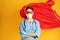 Doctor dressed as superhero posing on yellow background. Concept of medical workers fighting with COVID-19