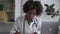 Doctor ehealth online service black therapist writes notes in clinic