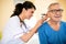 Doctor exam ear with otoscope at clinic of nursing home