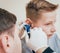 Doctor examines boy ear with otoscope. Medical equipment.