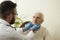 Doctor examines the lymph nodes on the neck of an old woman.