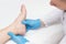 Doctor examines the patient`s leg with heel spurs, pain in the foot, white background, close-up, plantar fasciitis