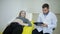 Doctor examines a pregnant woman and writes results to the medical card