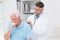 Doctor examining coughing senior patient