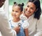 Doctor examining happy little girl by stethoscope. Child sitting with mother while male paediatrician listen to chest