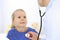 Doctor examining a little girl by stethoscope. Happy smiling child patient at usual medical inspection. Medicine and