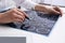 Doctor examining MRI images of patient with multiple sclerosis at white table in clinic, closeup