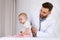 Doctor Examining Toddler Listening To Lungs With Stethoscope In Clinic