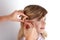 Doctor fitting a young girl patient with hearing aid