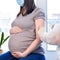 Doctor giving COVID-19 coronavirus vaccine injection to pregnant woman. Vaccination Young Pregnant Woman In Clinic. People