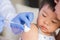 Doctor giving an injection vaccine to a girl.