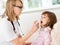 Doctor giving medical spray to little girl