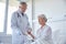 Doctor giving medicine to senior woman at hospital