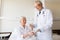 Doctor giving medicine to senior woman at hospital