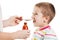 Doctor giving spoon of syrup to boy