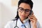 Doctor in glasses calling on phone at hospital