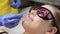 A doctor in gloves removes facial hair from a woman using a modern laser. Epilation for smooth skin