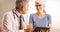 Doctor going over elderly woman`s health file in the office with tablet